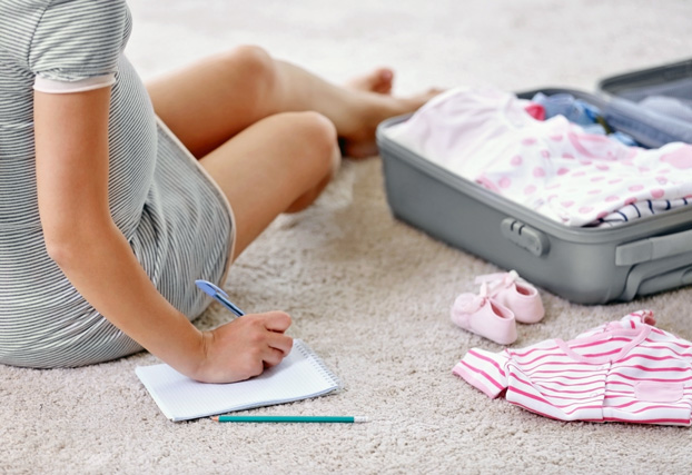 Pregnant Woman Packing Her Suitcase for the Maternity Hospital Stay When She Goes Into Labor