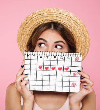 Woman Tracking Her Period on a Calendar