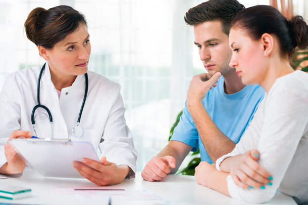 Doctor Consulting with Couple About Fertility Treatment Options