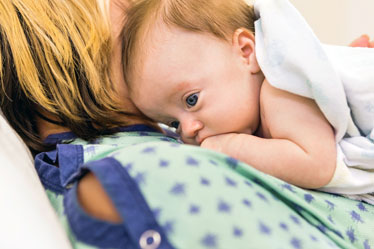 New Mother in Hospital with Newborn Infant Postpartum Care