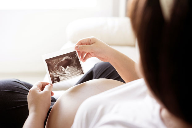 Pregnant Woman in Second Trimester Viewing Baby’s Ultrasound Images