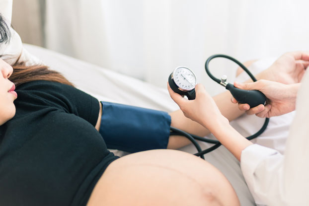 Obstetrician Monitoring Blood Pressure During a Pregnancy with Preeclampsia