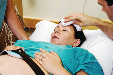 Husband Comforting Pregnant Wife During Labor Contractions