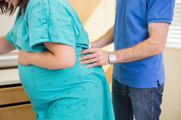 Husband Helping Wife with Back Pain During Labor