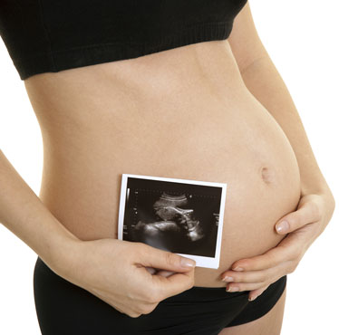 Pregnant Woman Holding Ultrasound Print End of First Trimester